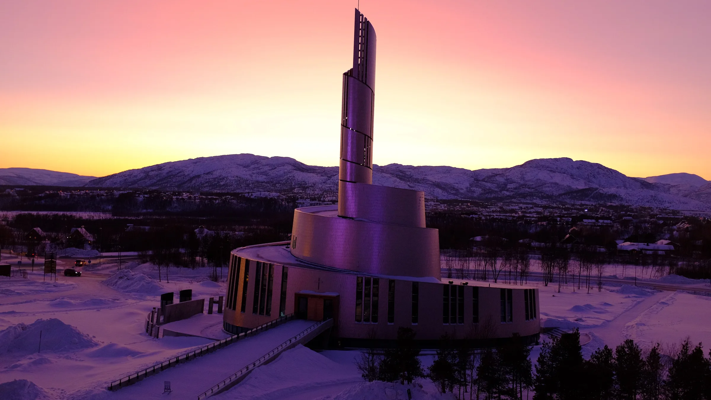 La cathédrale des aurores boréales d'Alta sous un ciel rose au crépuscule, en hiver, dans la neige du Finnmark