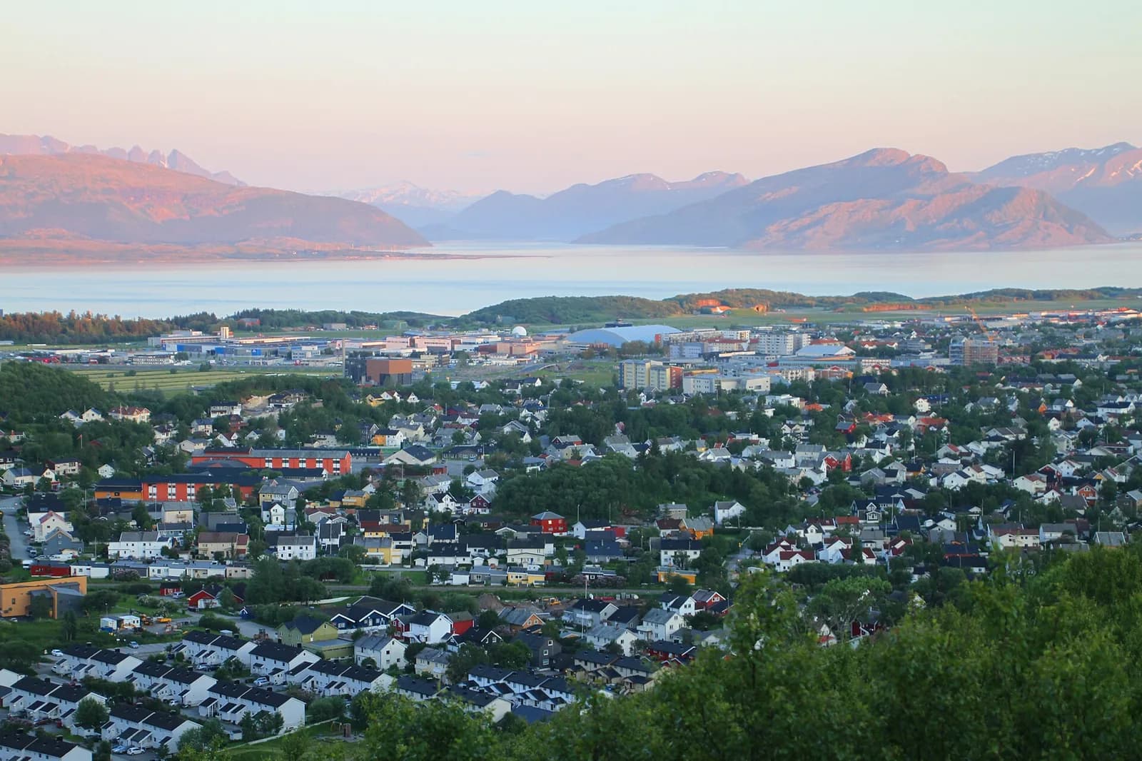 Vue en hauteur sur la ville de Bodø, le détroit et les montagnes à la lumière du soir