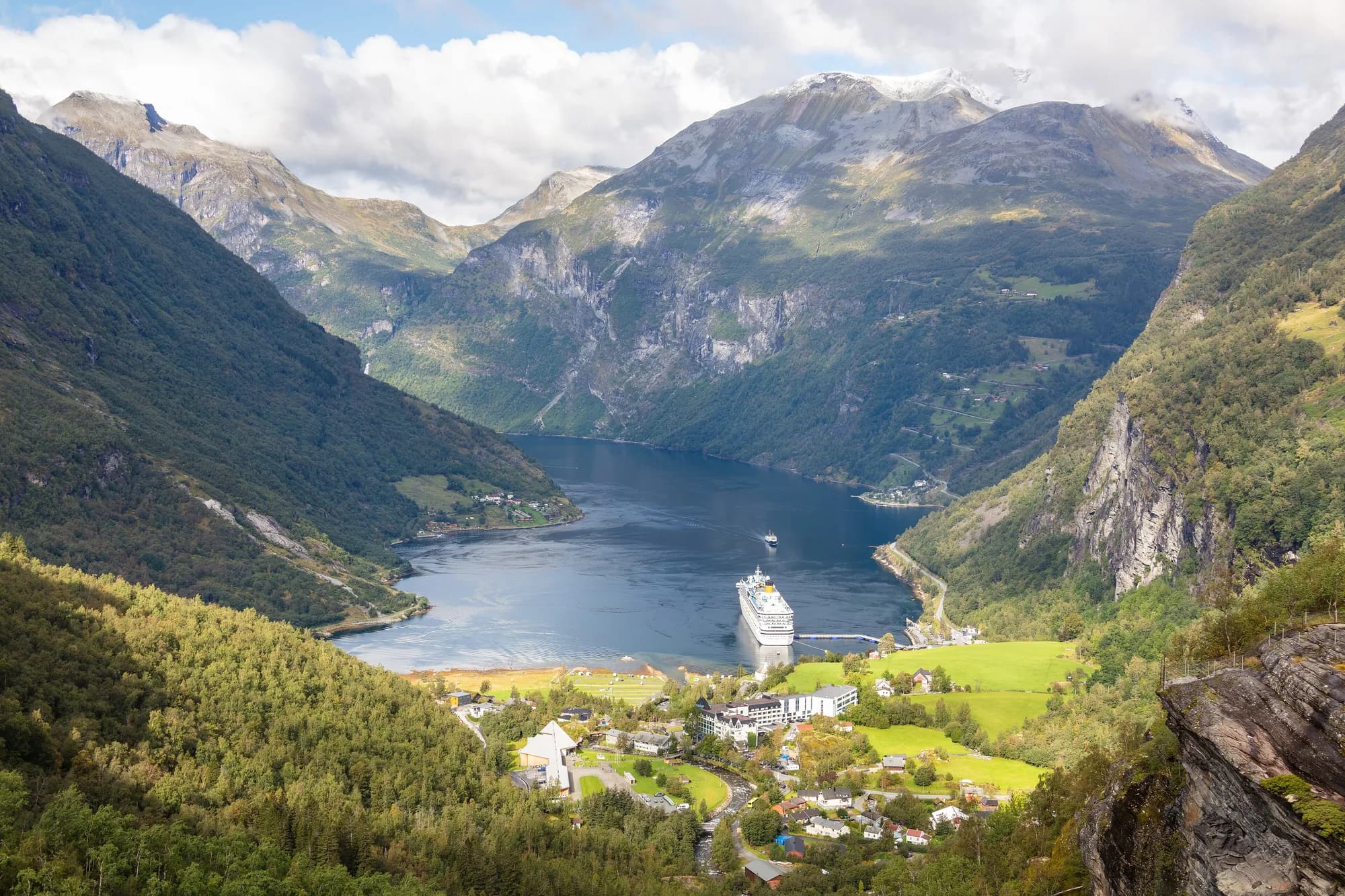 Le Geirangerfjord et le village de Geiranger vus depuis le belvédère de Flydalsjuvet, avec un paquebot au quai