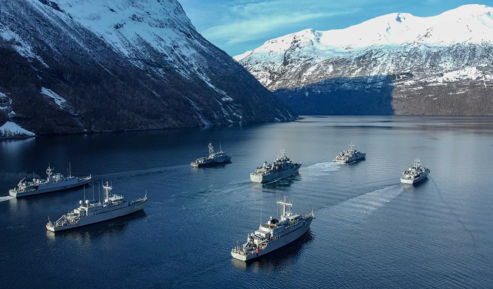 Le Geirangerfjord en hiver, versants couverts de neige, avec des navires sur l'eau